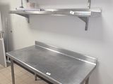 a large stainless steel table in the middle of a kitchen