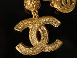 a close up of a gold chain with a chanel charm on it