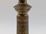 an antique brass candle holder on a white background