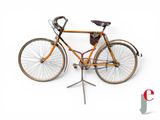 un vélo posé sur une béquille, sur fond blanc