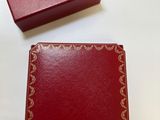 une boîte rouge ouverte posée sur une table, à côté d'une boîte rouge