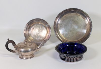 deux plats en argent et une théière en argent posés sur une table blanche