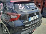 the back of a car with a sticker on it parked in front of a building