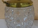 a glass jar with a gold lid sitting on a table