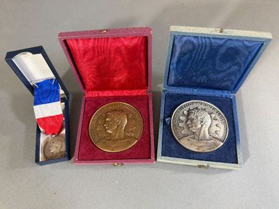 three medals in a box with a ribbon on top of it