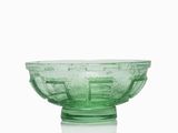 a green glass bowl sitting on top of a white table