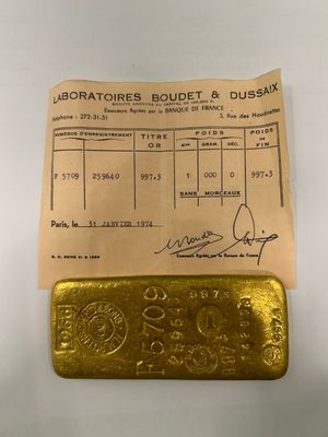 a gold bar sitting on top of a piece of paper