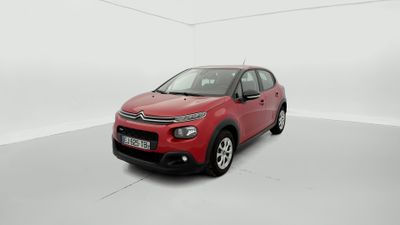Une Citroën rouge est garée dans une pièce blanche