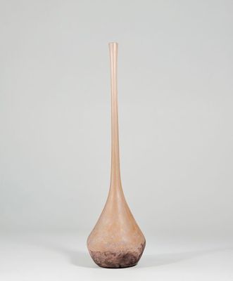 tall wooden vase sitting on a white surface with a gray background