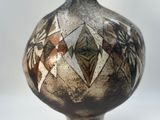 a vase with a design on it sitting on a table