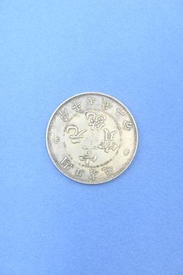 un gros plan d'une pièce d'argent posée sur une surface bleue