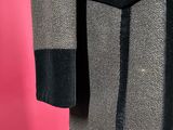 a grey and black jacket with a gold button on the front