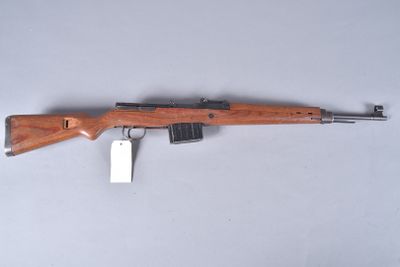 a rifle with a wooden barrel and a tag on it