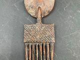 a close up of a metal comb on a black surface