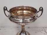 a silver plate with a handle on it on a table