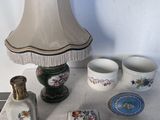 une table sur laquelle se trouvent une lampe, des tasses et d'autres objets