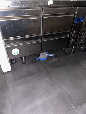 several ovens are lined up in a kitchen with a blue bucket