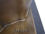 bronze statue of a cat on a marble base with a name plate
