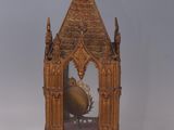 a clock that is sitting on a stand with a cross on top