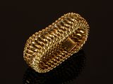 gros plan d'une bague en or sur une surface noire