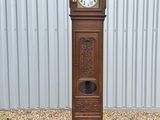 une grande horloge de parquet en bois posée sur le trottoir