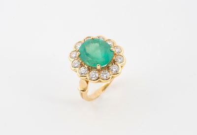 gros plan d'une bague avec une pierre verte entourée de diamants