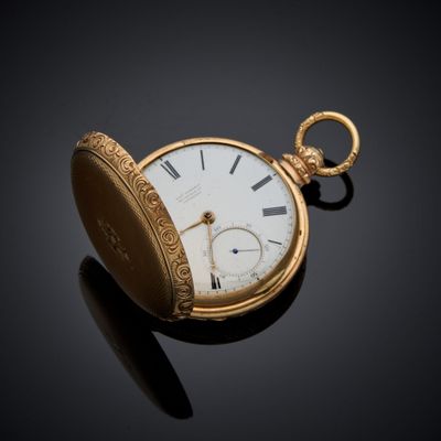 an image of a gold pocket watch sitting on a black surface