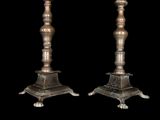pair of antique brass candlesticks on black background with black background