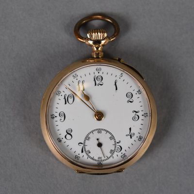 a close up of a gold pocket watch on a gray surface