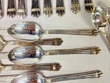 a lot of silver spoons and spoons on the table