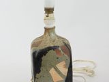 a small bottle with a painting on it sitting on a table