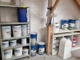 several buckets of paint on the shelves in the garage