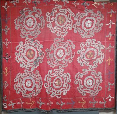 un vieux tissu brodé rouge et blanc orné de motifs floraux