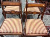 Quatre chaises en bois, dont les assises sont recouvertes d'un tissu rayé, se trouvent dans une pièce