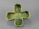 an image of a green cross shaped bowl with a face on it