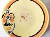 a yellow plate with a blue and orange design on it