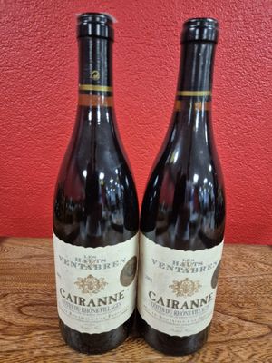 two bottles of wine sitting on top of a wooden table