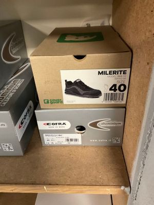 Deux boîtes de chaussures sont empilées sur une étagère dans un placard.