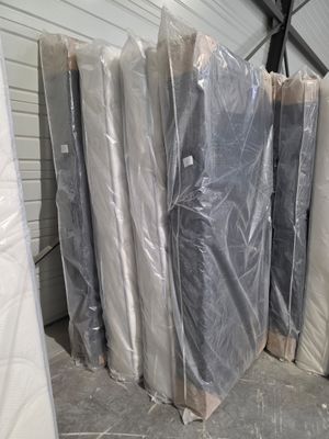 de nombreux matelas empilés dans une zone d'entrepôt