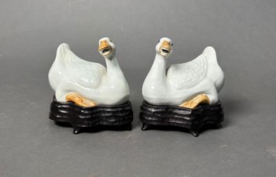 two figurines of swans sitting on top of each other