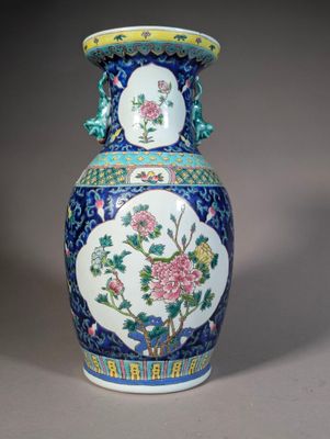 a blue and white vase with flowers and birds on it