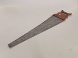 a close up of a wooden hand saw on a white surface