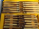 a lot of knives in a yellow case on a table