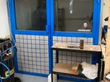 une pièce avec une porte bleue et un établi à l'intérieur