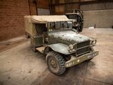 an old military truck parked in a garage