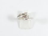 une bague sertie d'un diamant, posée sur une surface blanche