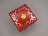 une petite boîte rouge ornée d'un médaillon doré