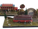 une maquette d'un bus rouge et un bus rouge avec des passagers à bord