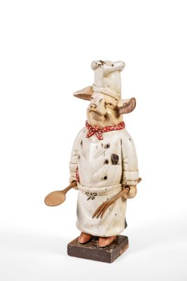 a figurine of a dog wearing a chef ' s hat and holding a spatula