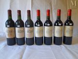 six bottles of wine are lined up on a table